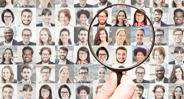 A magnifying glass hovers over a series of portrait photos, with the pictures underneath it sharper and brighter than the others A magnifying glass hovers over a series of portrait photos, with the pictures underneath it sharper and brighter than the others